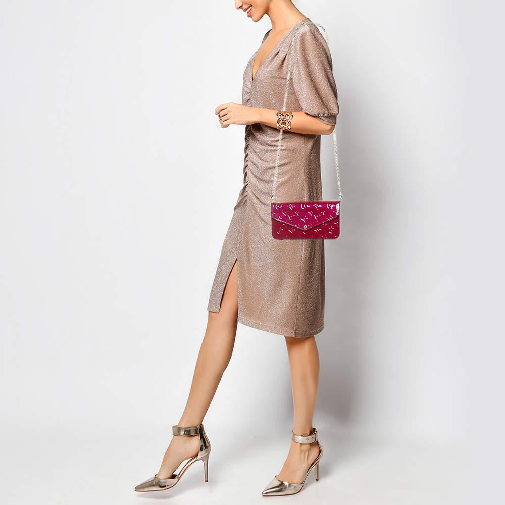 This Pochette Félicie has been designed to be a shoulder bag as well as a clutch. It is crafted from Amarante Monogram Vernis leather and has a canvas lined interior an envelope flap and a gold tone chain. The bag comes in a convenient size that you