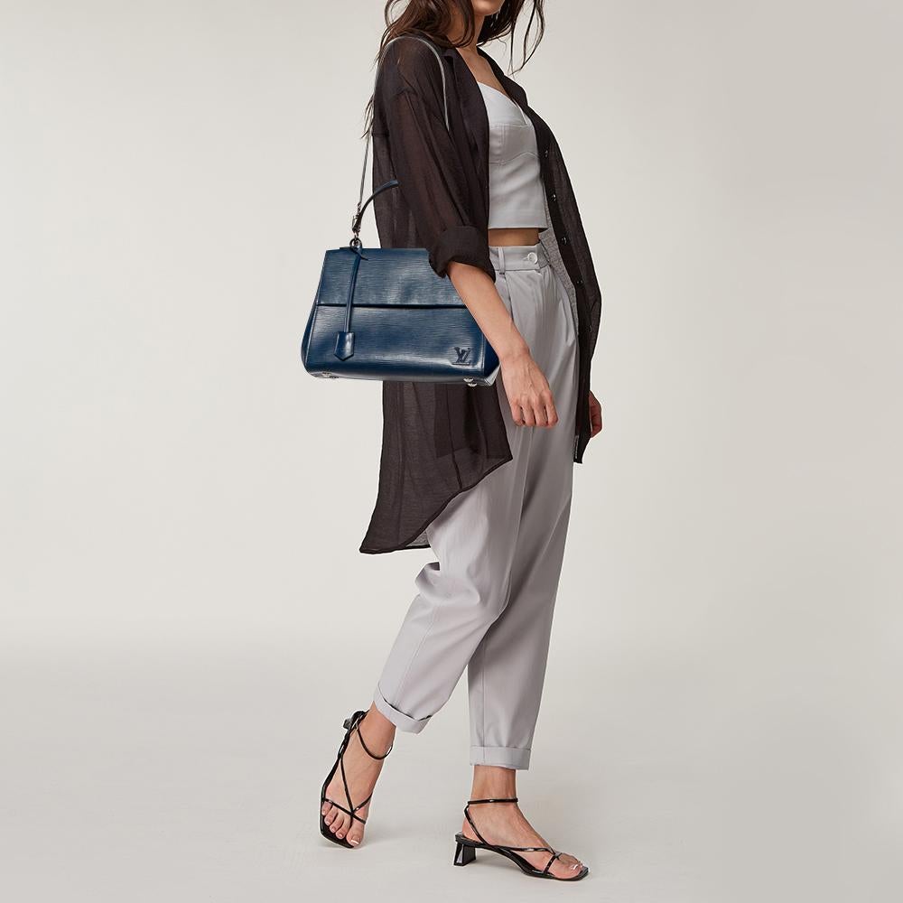 All of Louis Vuitton's handbags are high on style and craftsmanship. Created from their signature Epi leather, the Cluny bag has a fine finish and a sleek silhouette. The bag features a top handle, a detachable shoulder strap, protective feet at the