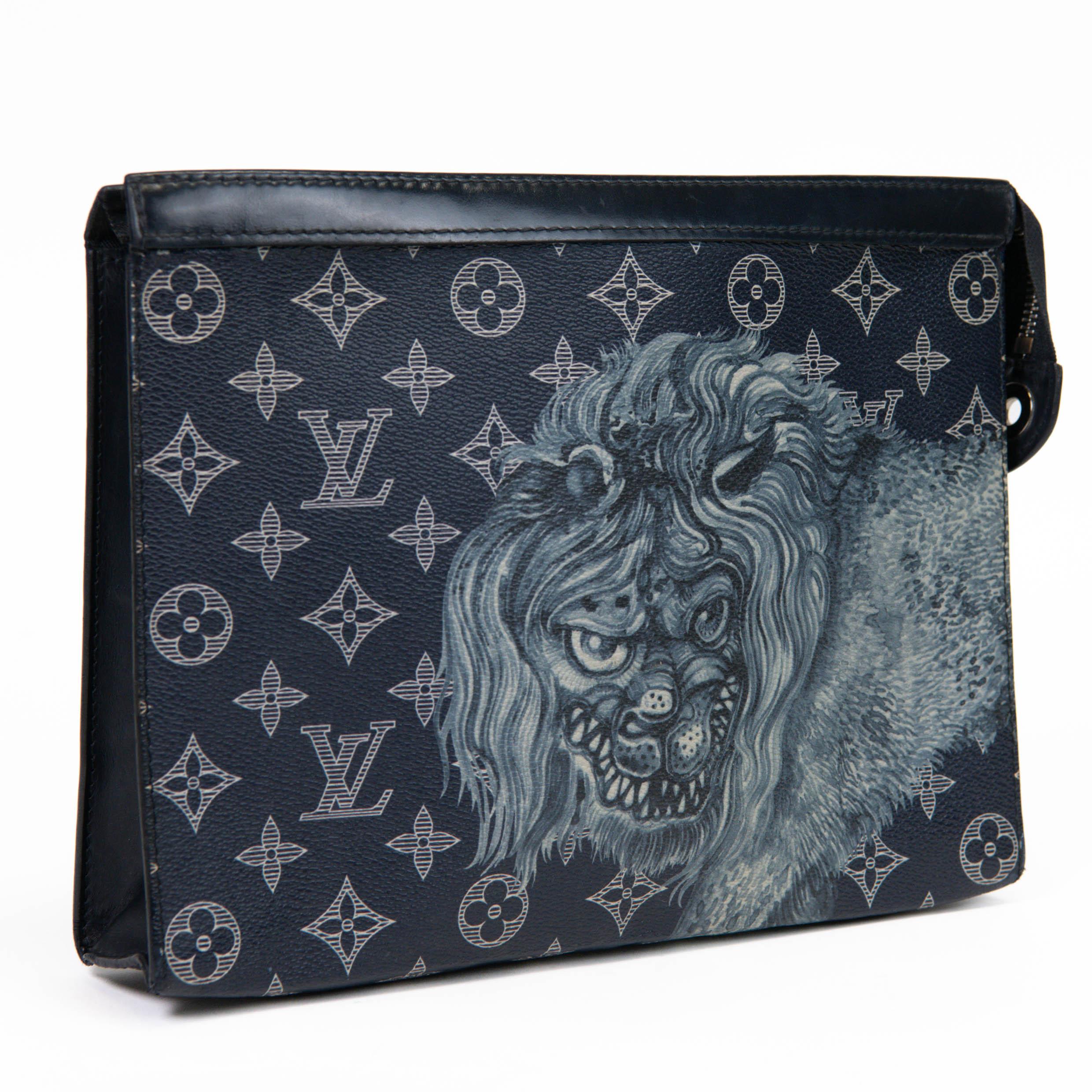 100% Authentic 

 This chic unisex pochette is featured in navy blue and white Louis Vuitton monogram canvas complemented with a large lion and navy leather trim. The top zipper opens with a polished silver zipper to a navy blue fabric and leather