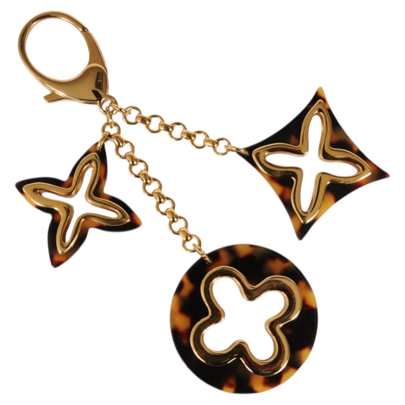Pendentif pour sac Louis Vuitton « Insolence » couleur or, motif écaille de tortue, porte-clés avec logo LV
