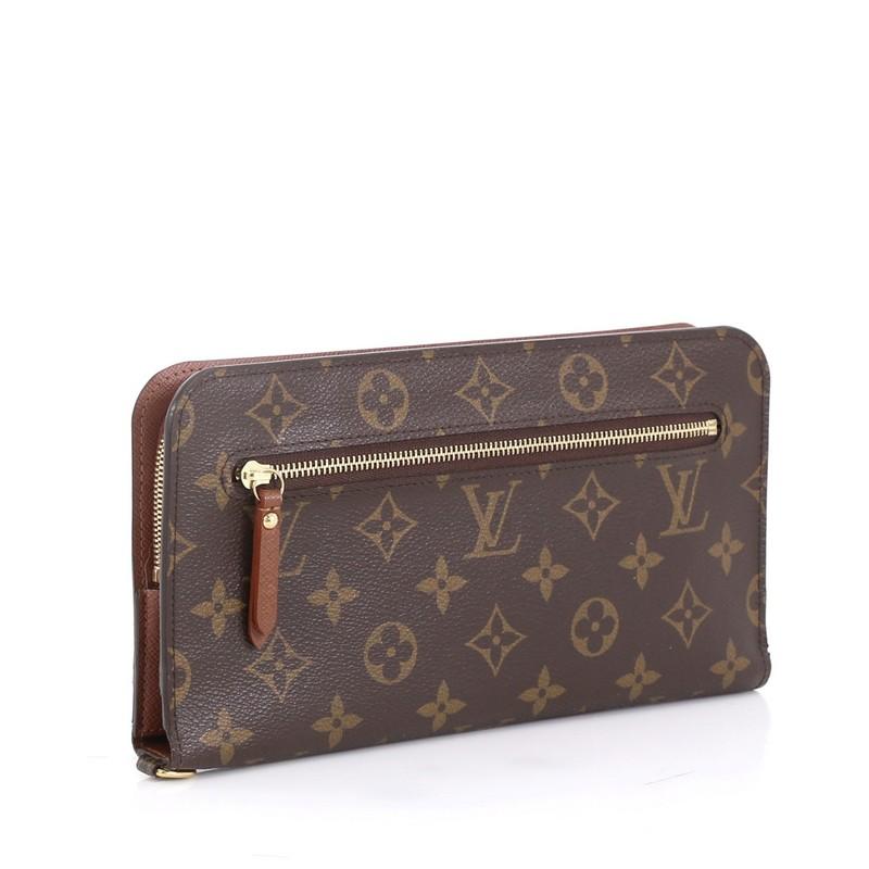 This Louis Vuitton Insolite Organizer Monogram Canvas, crafted from brown monogram coated canvas, features an exterior zip pocket, D ring and gold-tone hardware. Its double snap closure opens to a brown leather interior that showcases a zip pocket