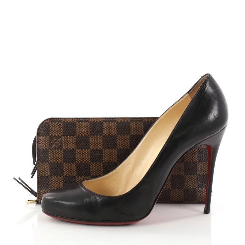 This authentic Louis Vuitton Insolite Wallet Damier is a unique functional wallet perfect for every fashionista. Crafted from the brand's classic damier ebene coated canvas, this eye-catching compact accessory features a dual zip opening, leather