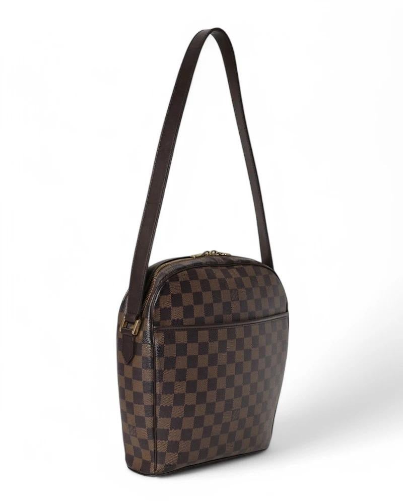 Louis Vuitton's signature Ipanema bag in size GM, made of brown canvas in the Damier Ebene pattern with leather trim and gold hardware. Featuring a semi-circular zipper closure, internally lined in red suede fabric with convenient pockets, the bag