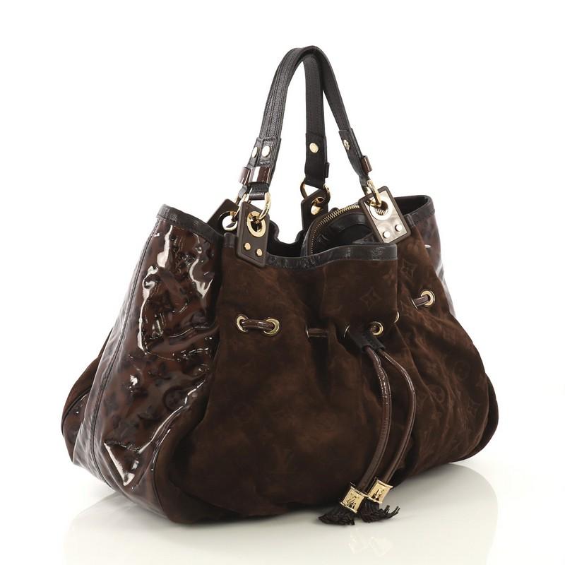 This Louis Vuitton Irene Handbag Monogram Embossed Suede and Patent, crafted from brown monogram embossed suede and patent leather, features dual flat handles, leather trim, pleated details, drawstring with leather tassel tips, protective base