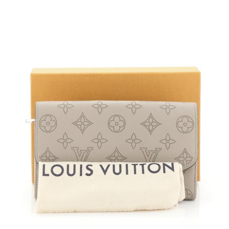 This Louis Vuitton Iris Wallet NM Mahina Leather, crafted from neutral mahina leather, features silver-tone hardware. Its snap button closure opens to a neutral leather interior with multiple card slots, middle zip pocket, and slip pocket.