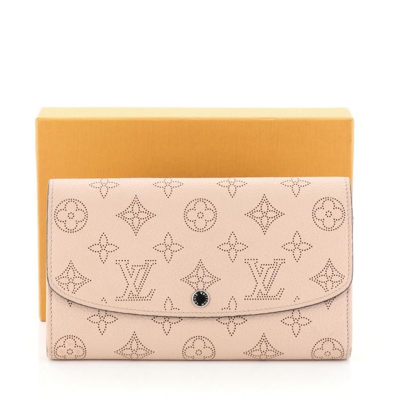 This Louis Vuitton Iris Wallet NM Mahina Leather, crafted from pink mahina leather, features silver-tone hardware. Its snap button closure opens to a pink leather interior with multiple card slots, middle zip pocket, and slip pocket. Authenticity