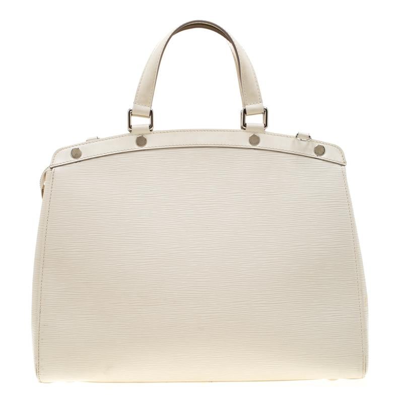 The feminine shape of Louis Vuitton's Brea is inspired by the doctor's bag. Crafted from the signature Epi leather in white, the bag has a textured finish. The fabric interior is spacious and it is secured by a zipper. The bag features double