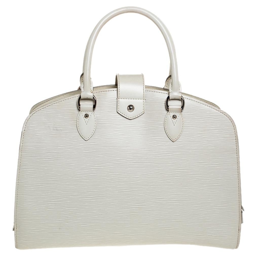 Made from the work of proficient craftsmen, this ivory-colored bag is designed with epi leather exterior and skillfully lined Akcantara insides that provide space as well as durability. Secured by a silver-tone zipper, this Pont Neuf bag can hold a