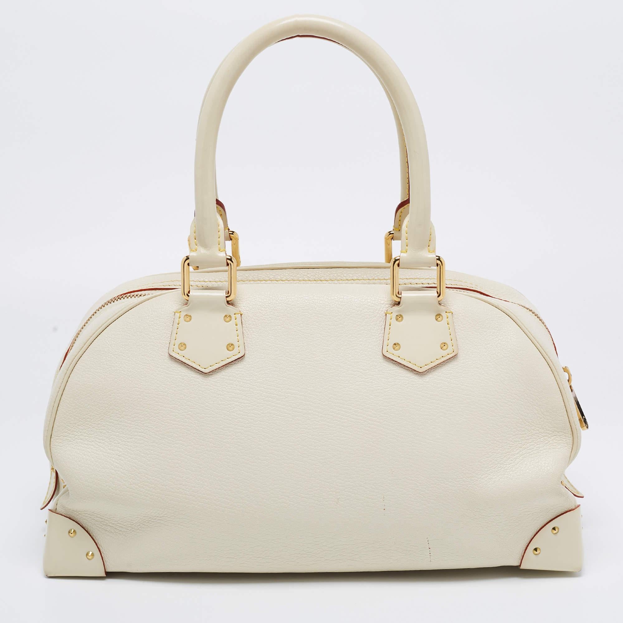 This limited edition Louis Vuitton bag is the perfect everyday bag. Made from ivory Suhali leather, it has a front flap pocket, gold-tone metal accents, and two top handles.

