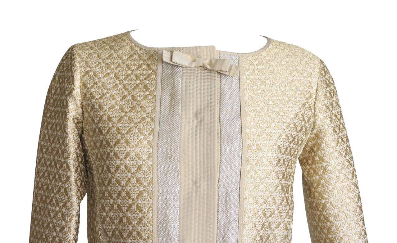 Louis Vuitton exquisitely detailed brocade jacket.  
3/4 Sleeve short jacket edged and detailed in irridescent fabric that moves from soft gold to soft silver.
Gold brocade has subtle metallic.
Single breast with hidden snaps.  Nude plaquet and bow