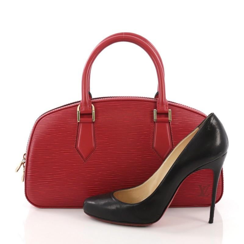 This Louis Vuitton Jasmin Bag Epi Leather, crafted with red epi leather, features dual rolled leather handles, subtle LV logo at the front, and gold-tone hardware. Its all-around zip closure opens to a red microfiber interior with slip pocket.
