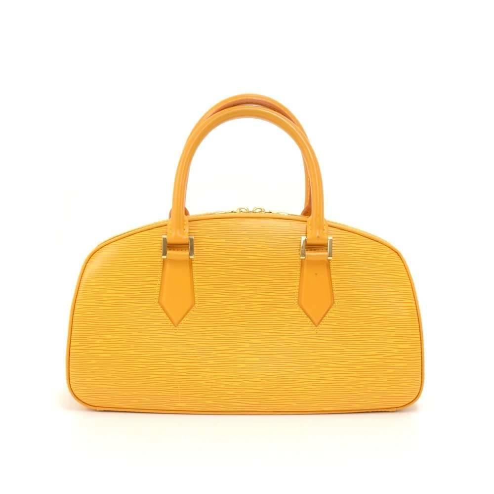 Louis Vuitton Jasmin in yellow Epi leather. It is secured with double brass zipper. Inside has a lovely purple alkantra lining with 1 open pocket. Carried in hand. LV embossed on the front. Simple and classy design makes this discontinued bag very