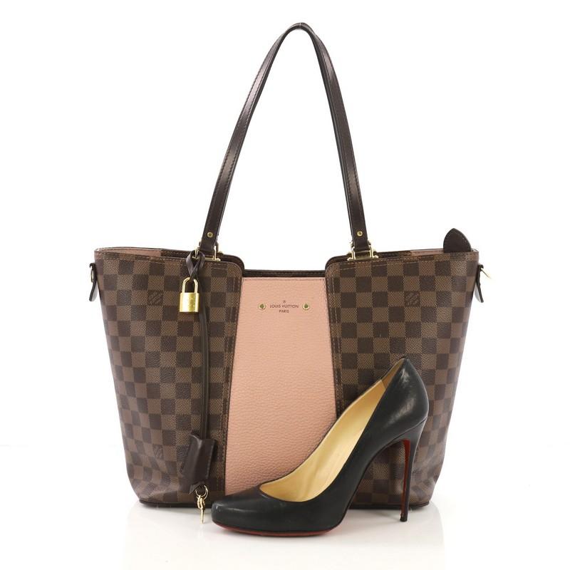 This Louis Vuitton Jersey Handbag Damier with Leather, crafted in damier ebene coated canvas with leather, features dual flat leather handles, protective base studs, and gold-tone hardware. Its zip closure opens to a pink microfiber interior with