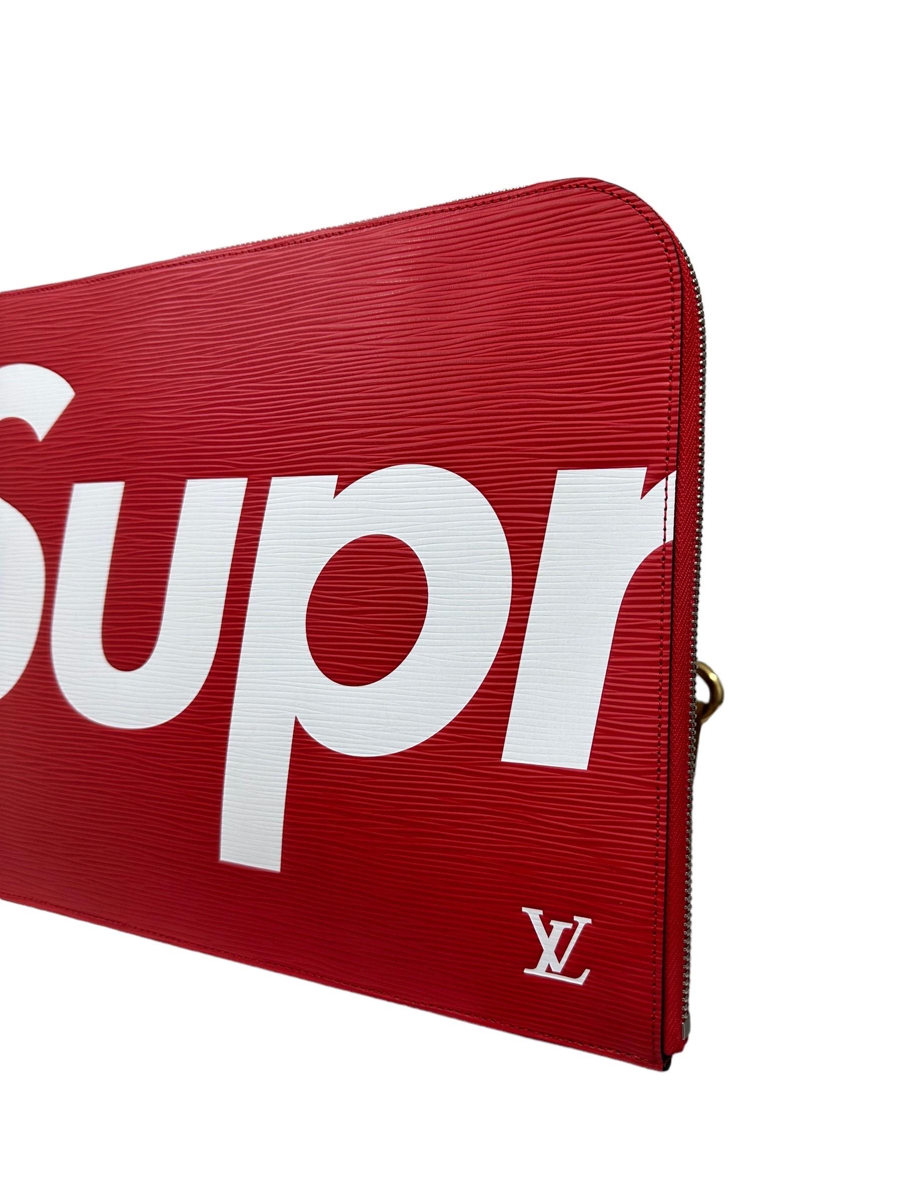 Pochette signée Louis Vuitton, modèle Jour, taille GM, édition limitée en collaboration avec Supreme. Fabriqué en cuir rouge, avec des lettres blanches sur le devant et le dos et des pièces argentées. Doté d'une fermeture à glissière, doublé à