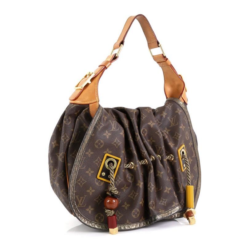 This Louis Vuitton Kalahari Handbag Monogram Canvas GM, crafted in brown monogram coated canvas, features single loop vachetta handle, pleated front details with drawstring rope accents, polished red and yellow resin beads, and gold-tone hardware.