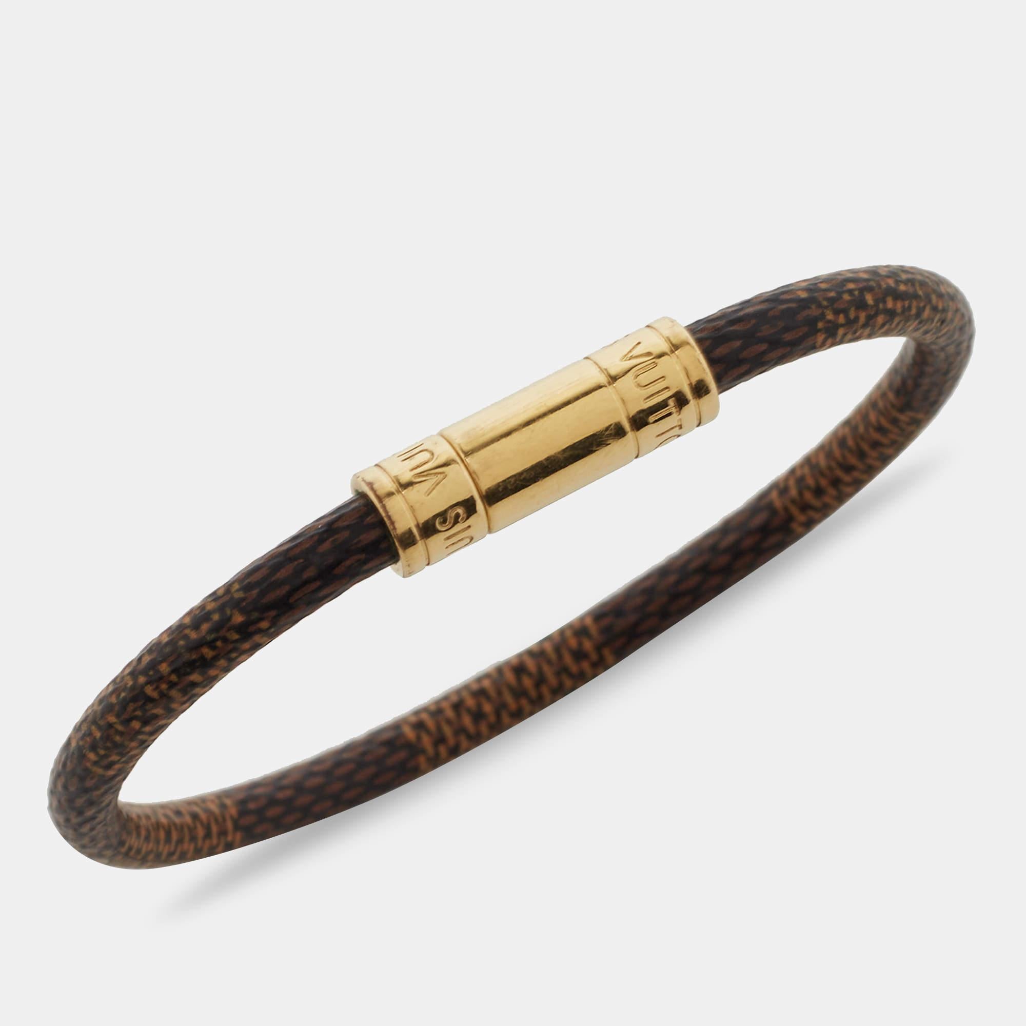 Simple yet elegant, this Louis Vuitton Keep It bracelet is designed with the label's Damier Ebene canvas and features a gold-tone metal closure. Wear it as a stand-alone piece or stack it with similar bands for a layered effect.


