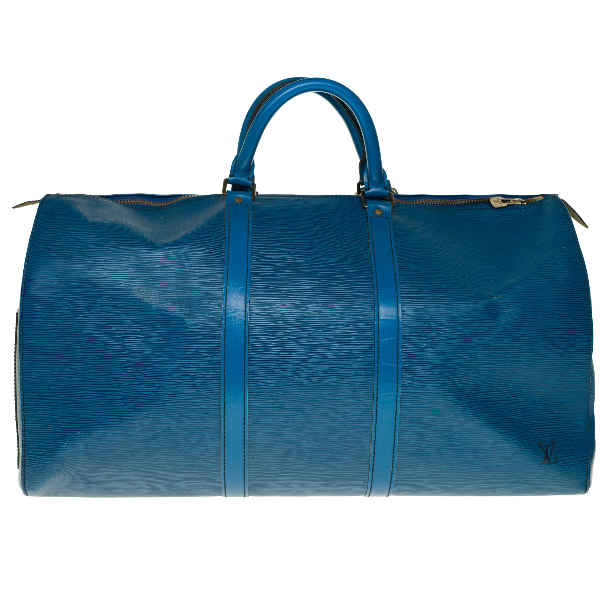 Classic travel bag Louis Vuitton Keepall 55 cm in blue epi leather with gold metal trim, double handle in blue leather allowing a handheld.

Double zipper.
Lining in blue suede.
Signature: 