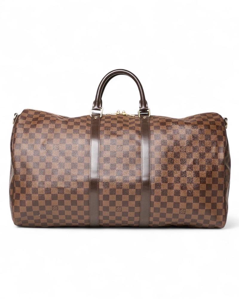 Reisetasche der Firma Louis Vuitton, Modell Keepall in der Größe 55, aus Leder in der klassischen Damierebene mit Einsätzen aus Marmorpelle und verschnörkelten Beschlägen. Mit einem oberen Reißverschluss mit zwei Kordeln, intern in Marmorleder