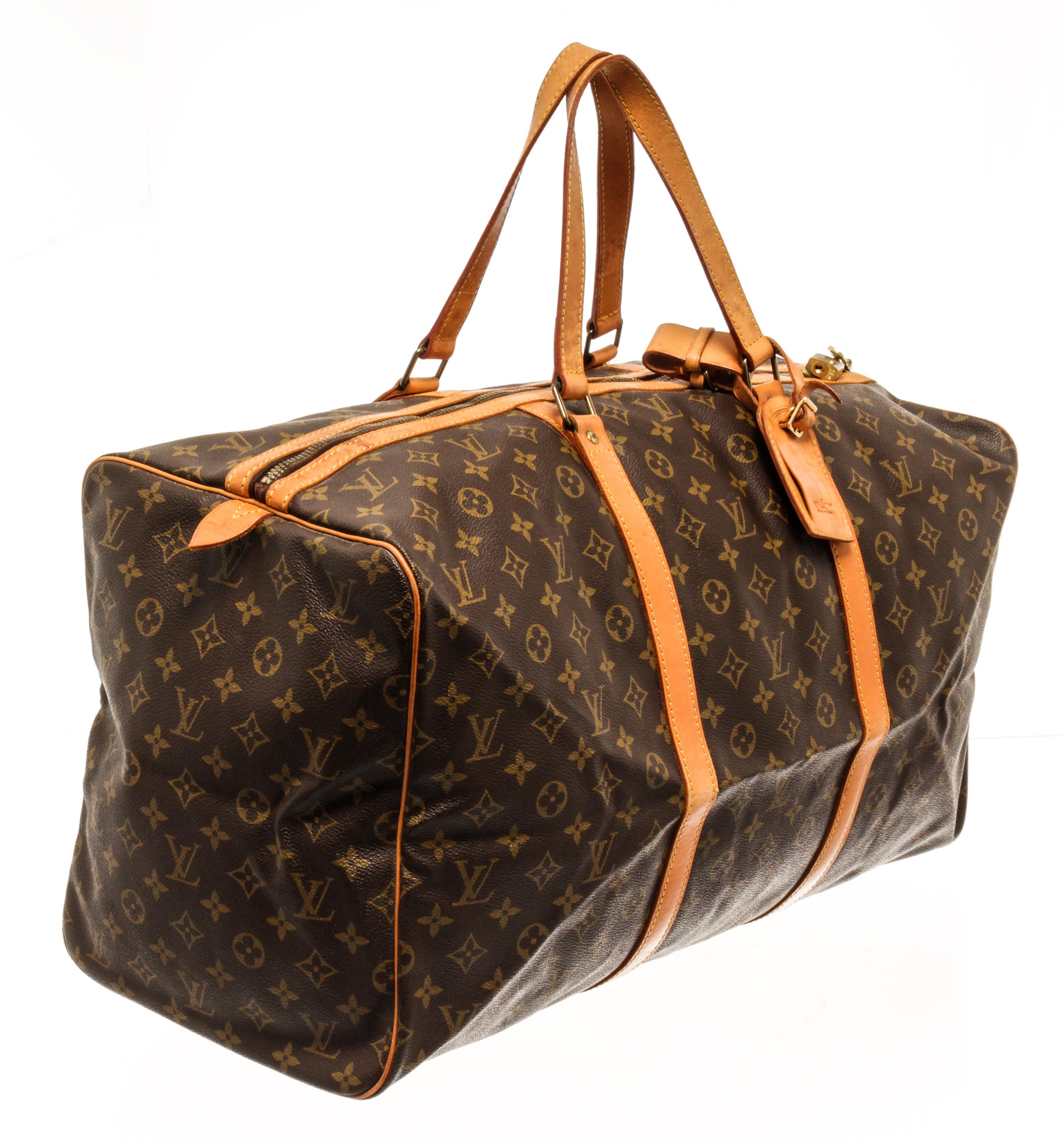 Louis Vuitton Keepall 55 cm duffel bag with monogram coated canvas exterior, contrasting vanchetta leather trims and top handles, brown fabric lining, top zipper closure, gold-tone hardware, lock, and a luggage tag. 

82262MSC