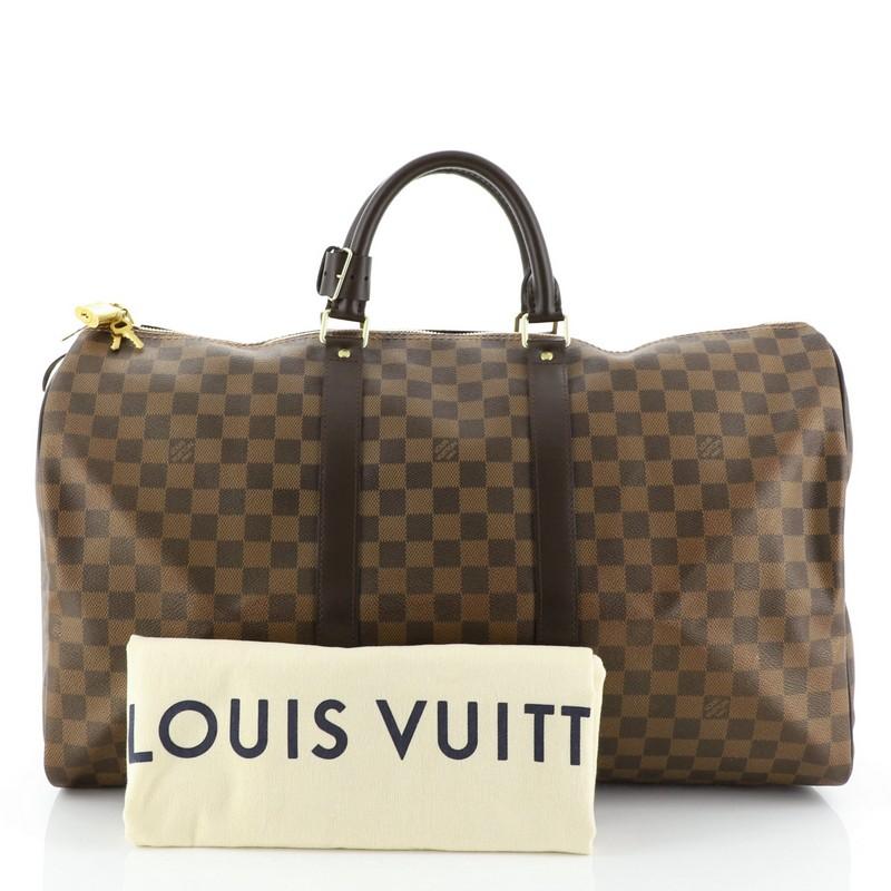 This Louis Vuitton Keepall Bag Damier 50, crafted from damier ebene coated canvas, features dual rolled handles, leather trim, and gold-tone hardware. Its two-way zip closure opens to a brown fabric interior. Authenticity code reads: MB4177.