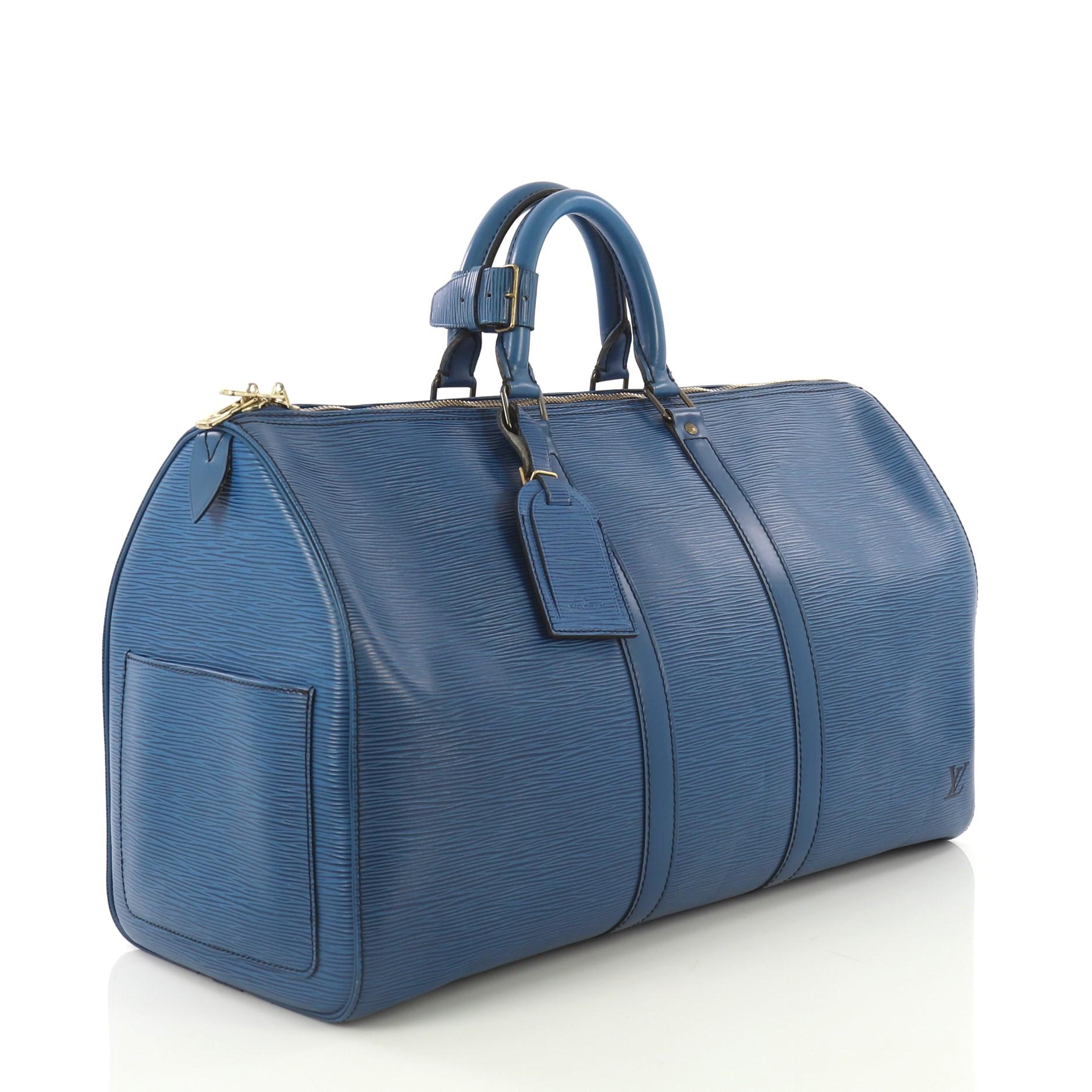 This Louis Vuitton Keepall Bag Epi Leather 45, crafted from blue epi leather, features dual rolled handles, subtle LV logo, and gold-tone hardware. Its zip closure opens to a blue raw leather interior. Authenticity code reads: VI0970. 

Estimated