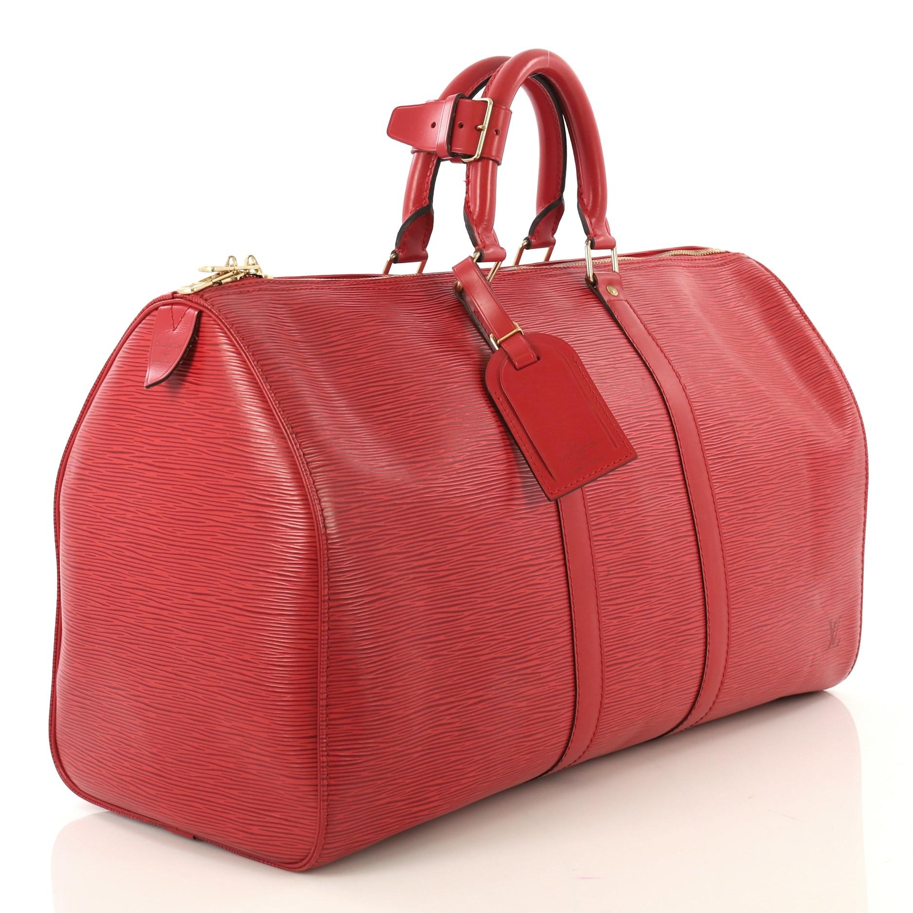 This Louis Vuitton Keepall Bag Epi Leather 45, crafted from red epi leather, features dual rolled handles, subtle LV logo, and gold-tone hardware. Its zip closure opens to a red raw leather interior. Authenticity code reads: V10923. 

Estimated