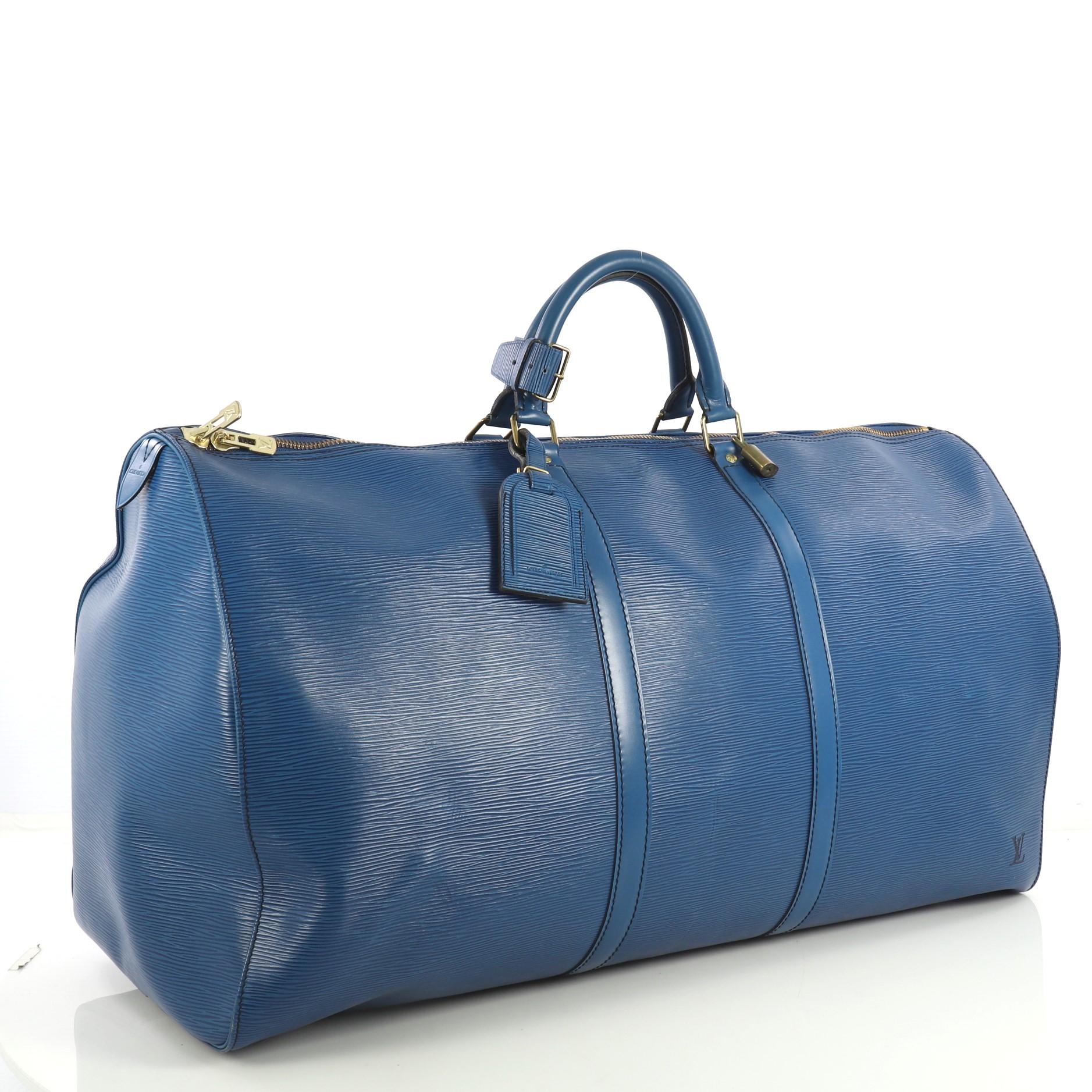 This Louis Vuitton Keepall Bag Epi Leather 60, crafted from blue epi leather, features dual rolled leather handles, subtle LV logo, exterior slip pocket and gold-tone hardware. Its two-way zip closure opens to a blue raw leather interior.