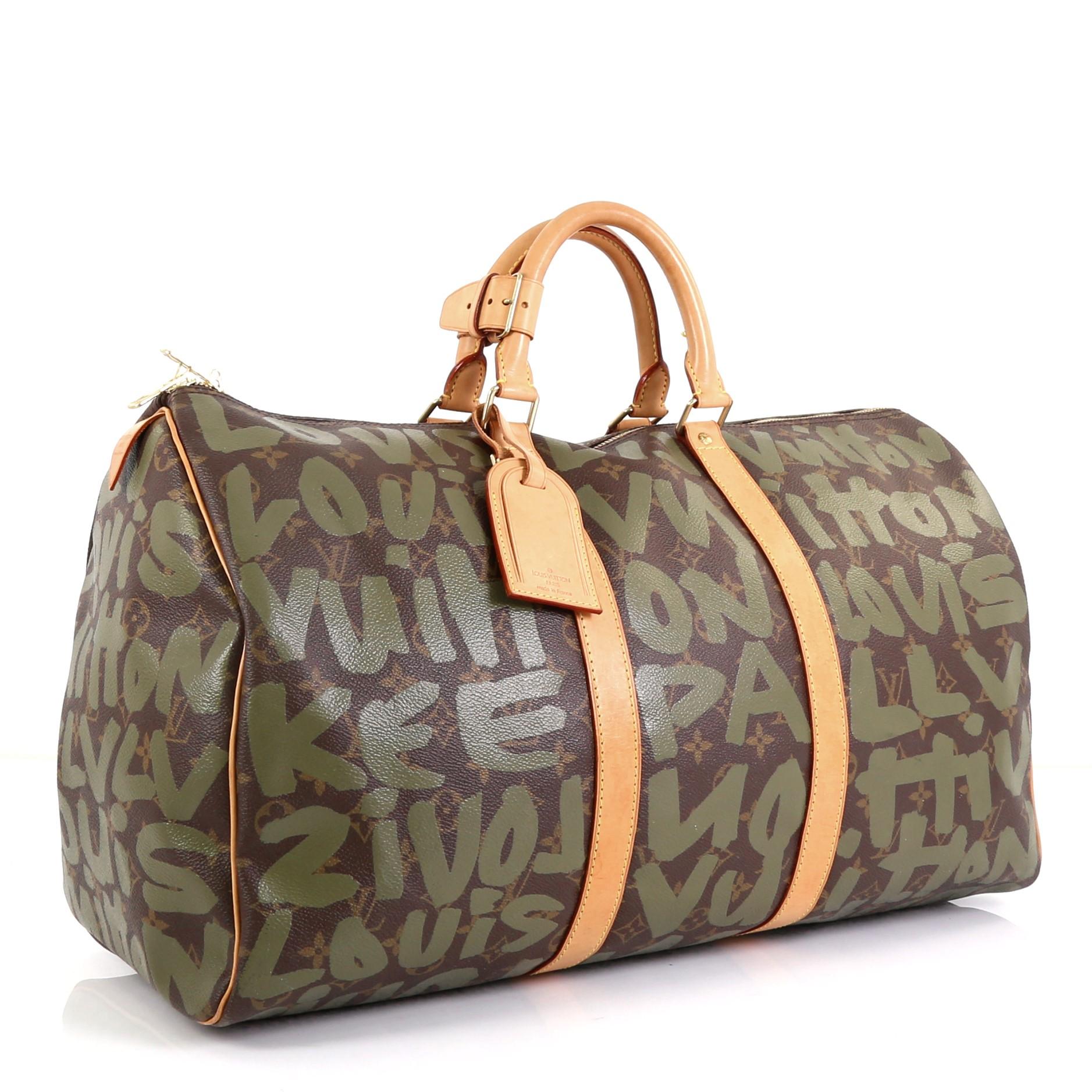 This Louis Vuitton Keepall Bag Limited Edition Monogram Graffiti 50, crafted from brown monogram and green graffiti coated canvas, features dual rolled handles, natural cowhide leather trim, graffiti print by Stephen Sprouse, and gold-tone hardware.