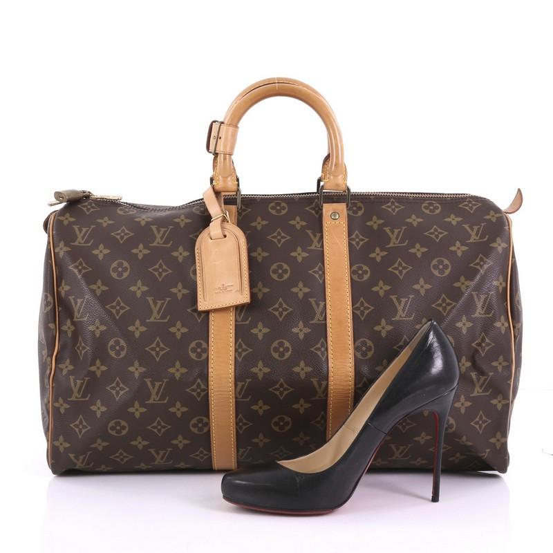 This Louis Vuitton Keepall Bag Monogram Canvas 45, crafted in brown monogram coated canvas, features dual rolled leather handles, vachetta leather trim, and gold-tone hardware. Its two-way zip closure opens to a brown fabric interior. Authenticity