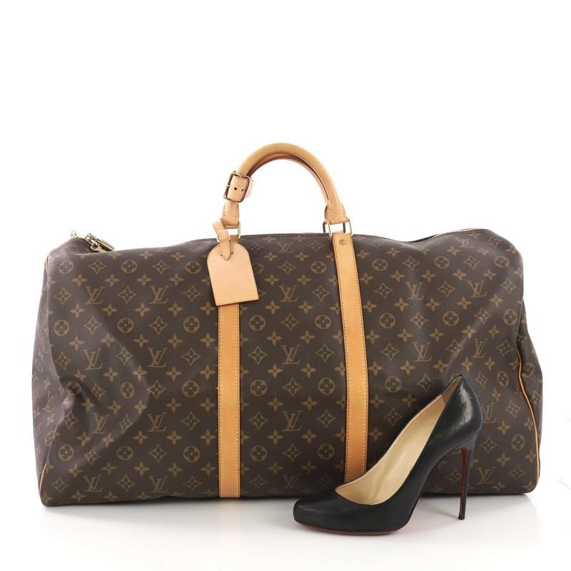 This Louis Vuitton Keepall Bag Monogram Canvas 60, crafted from brown monogram coated canvas, features dual rolled handles, natural cowhide leather trims, and gold-tone hardware. Its zip closure opens to a brown fabric interior. Authenticity code