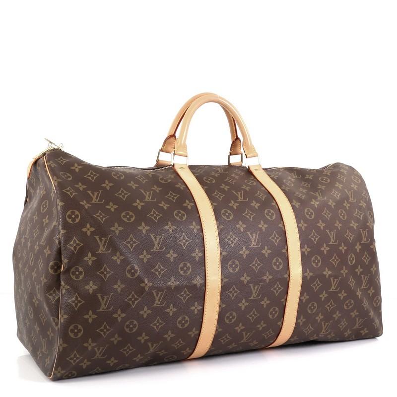 This Louis Vuitton Keepall Bag Monogram Canvas 60, crafted in brown monogram coated canvas, features dual rolled leather handles, vachetta leather trim, and gold-tone hardware. Its two-way zip closure opens to a brown fabric interior. Authenticity