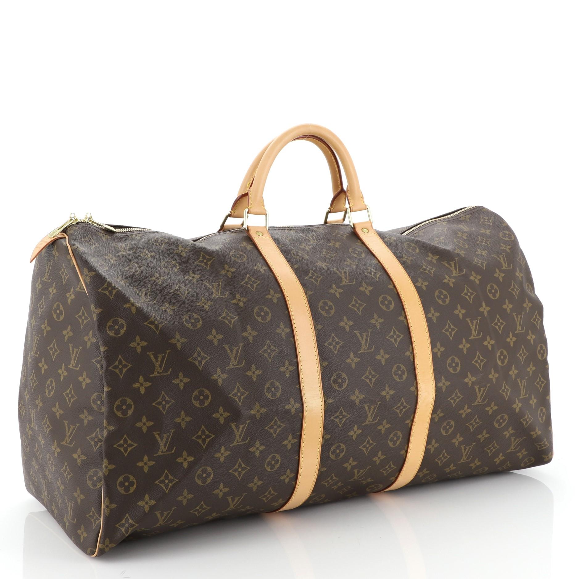 This Louis Vuitton Keepall Bag Monogram Canvas 60, crafted in brown monogram coated canvas, features dual rolled leather handles, vachetta leather trim, and gold-tone hardware. Its two-way zip closure opens to a brown fabric interior. Authenticity