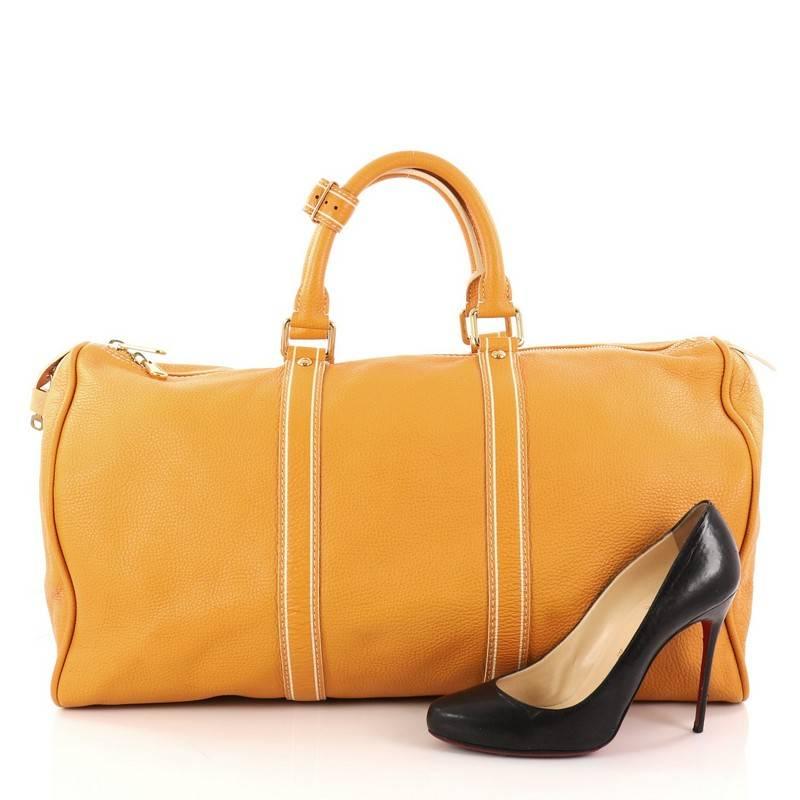 This authentic Louis Vuitton Keepall Bag Tobago Leather 50 is a sophisticated duffle perfect for traveling in style. Crafted in yellow tobago leather, this oversized duffle features dual-rolled leather handles, standout contrast stitching,