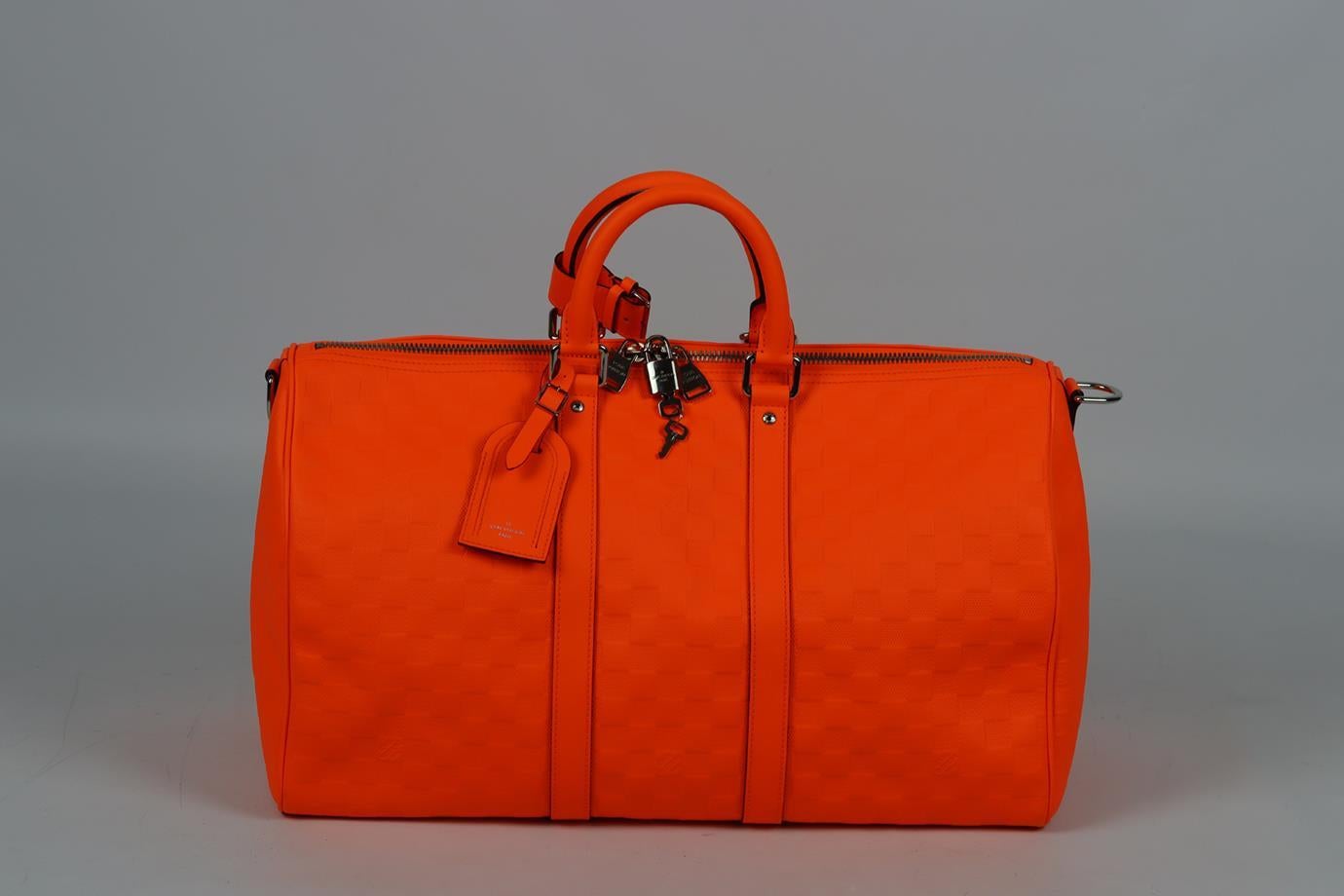 Louis Vuitton Keepall Boudoulière 45 Damier Infini leather travel bag. Made from neon-orange Damier Infini embossed leather with matching leather handles and strap, it has a large internal compartments with slit and zip pockets. Orange. Zip