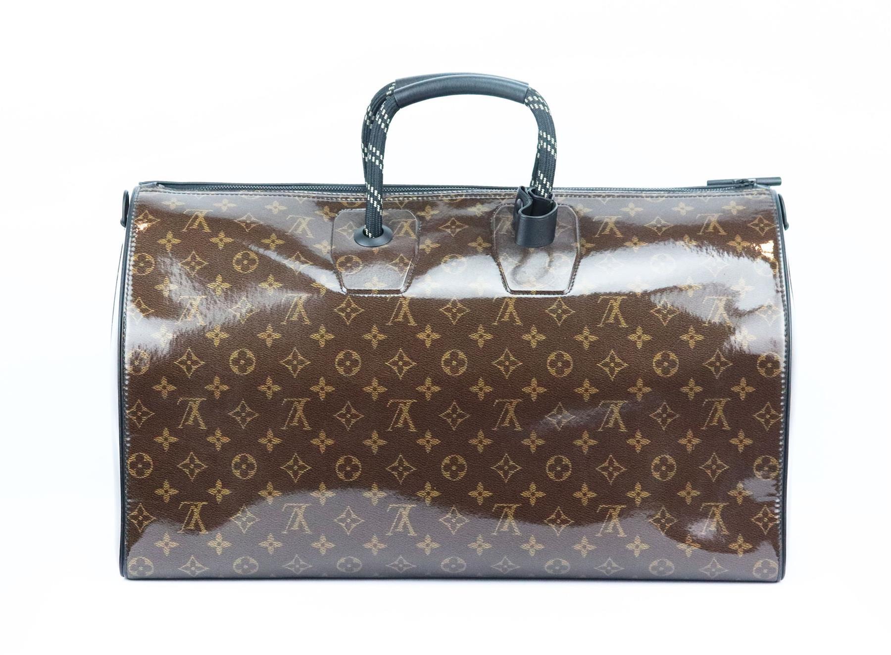 This 2018 ‘Keepall Bandoulière 50’ travel bag by Louis Vuitton is inspired by a classic duffle bag re-imagined, crafted from tonal-brown Monogram glaze canvas and lined in black canvas with black leather and rope handles and shoulder strap, it has