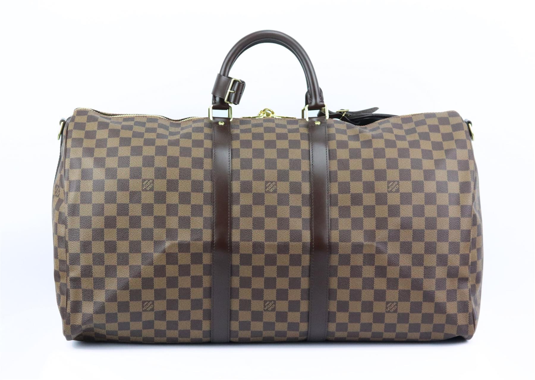 This ‘Keepall Bandoulière 55’ travel bag by Louis Vuitton is inspired by a classic duffle bag re-imagined, crafted from tonal brown ‘Damier Ebene’ coated canvas and lined in brown canvas with brown leather handles and shoulder strap and personalised