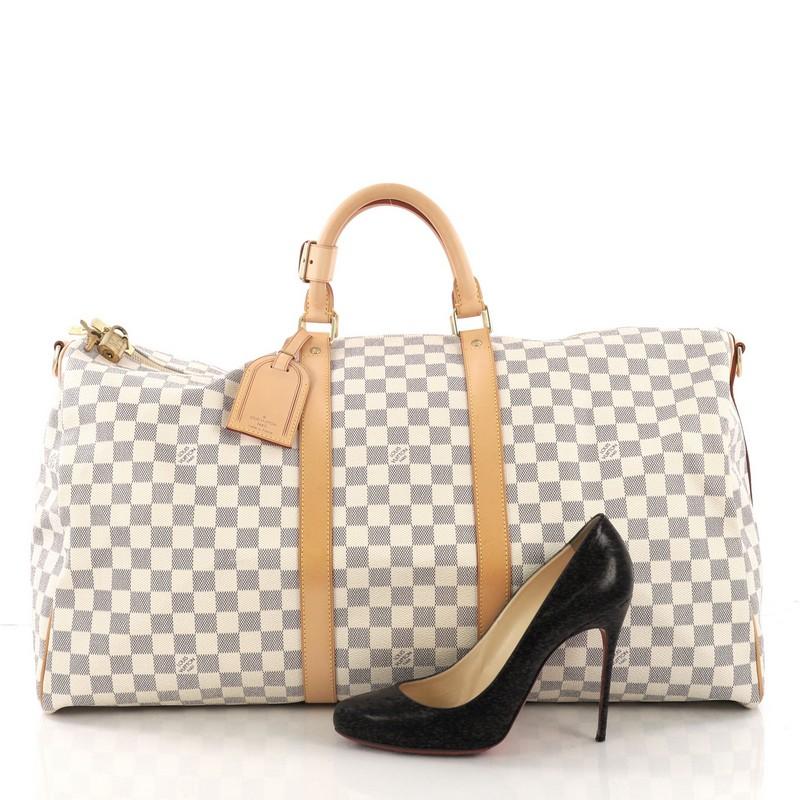 This Louis Vuitton Keepall Bandouliere Bag Damier 55 crafted from damier azur coated canvas, features dual rolled handles, leather trim, and gold-tone hardware. Its two-way top zip closure opens to a beige fabric interior. Authenticity code reads: