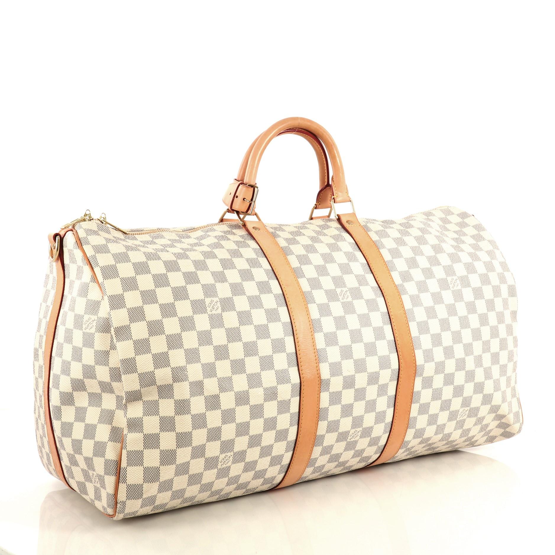 This Louis Vuitton Keepall Bandouliere Bag Damier 55, crafted with damier azur coated canvas, features dual rolled handles, leather trim, and gold-tone hardware. Its zip closure opens to a neutral fabric interior. Authenticity code reads: MB0047.