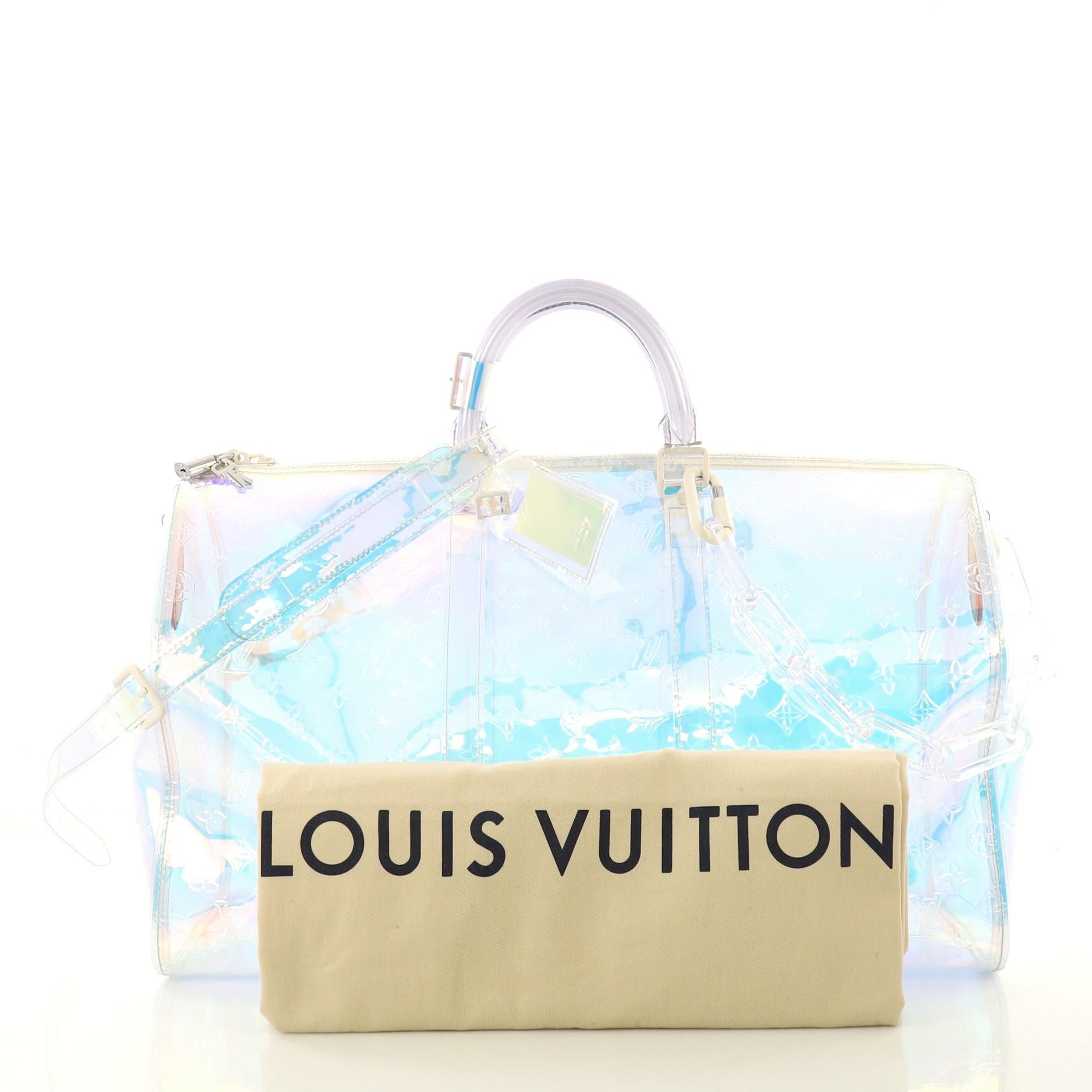 This Louis Vuitton Keepall Bandouliere Bag Limited Edition Monogram Prism PVC 50, crafted in iridescent monogram prism PVC, features dual rolled handles, resin chain, and white-tone hardware. Its zip closure opens to an iridescent monogram prism PVC