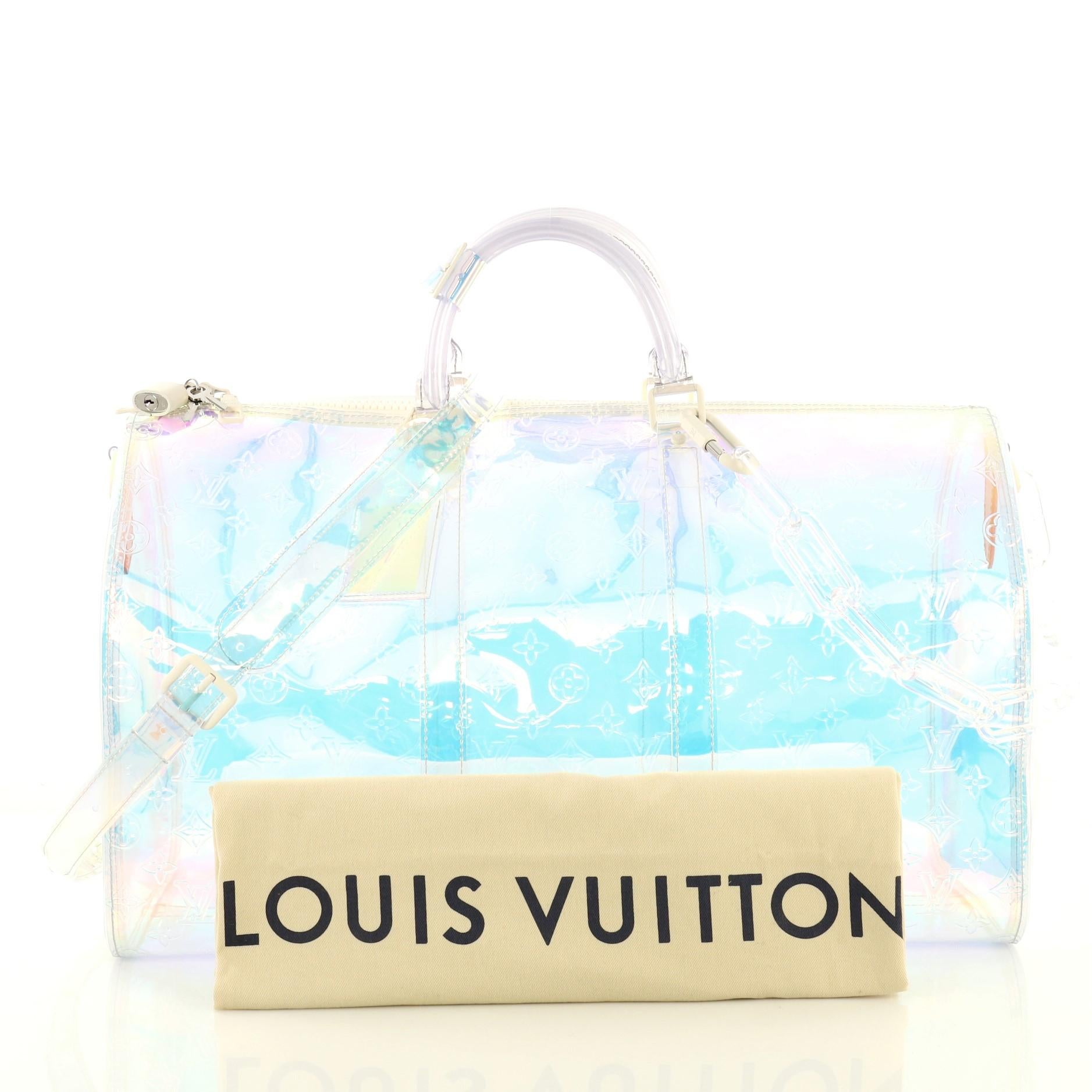This Louis Vuitton Keepall Bandouliere Bag Limited Edition Monogram Prism PVC 50, crafted in clear monogram prism PVC, features dual rolled handles, resin chain, and silver-tone hardware. Its zip closure opens to a multicolor and clear monogram