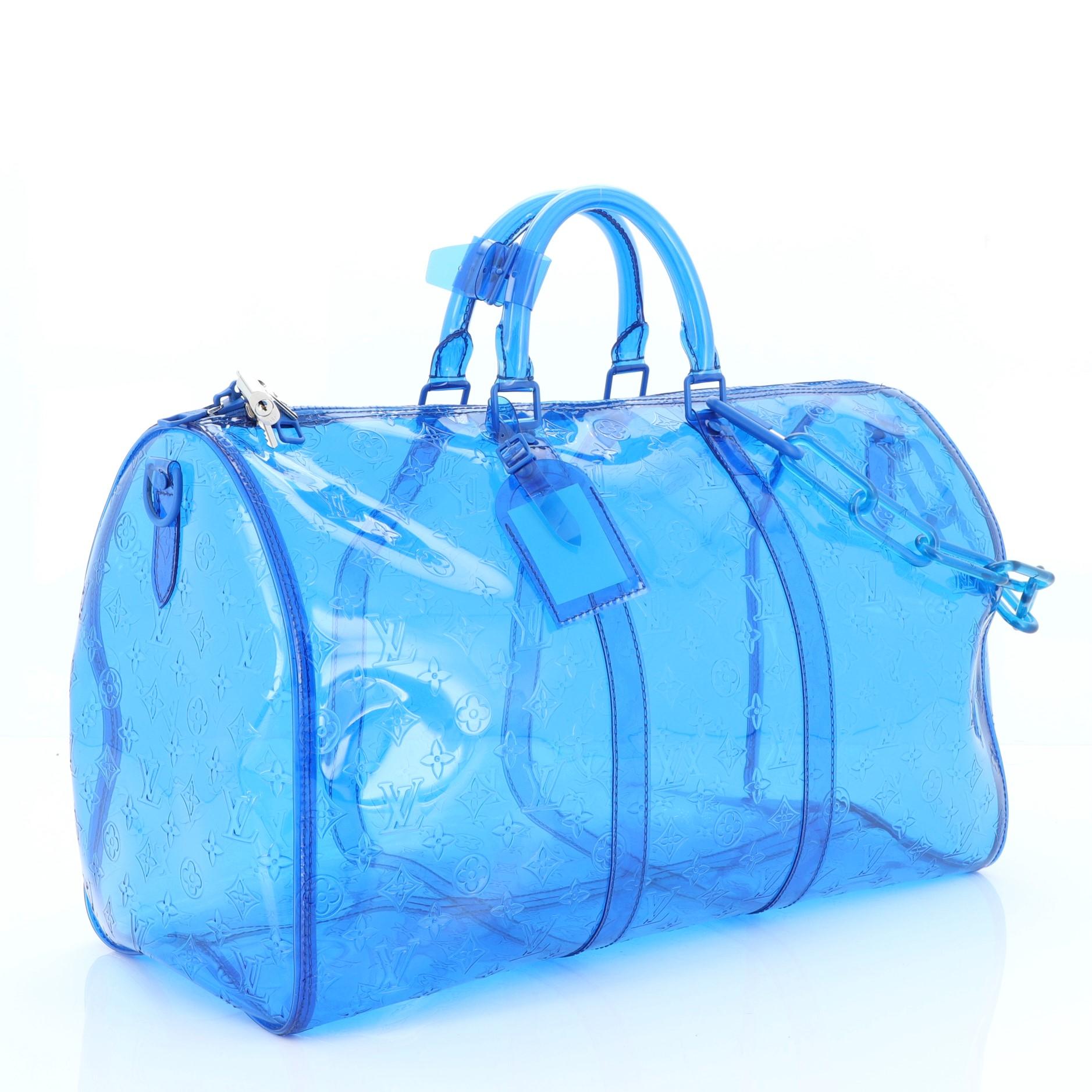 This Louis Vuitton Keepall Bandouliere Bag Limited Edition Monogram PVC 50, crafted in blue PVC, features dual rolled handles, resin chain, and silver-tone hardware. Its zip closure opens to a black PVC interior. Authenticity code reads: BA4168.