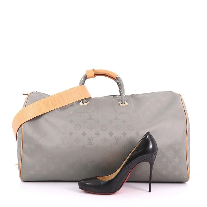 This Louis Vuitton Keepall Bandouliere Bag Limited Edition Titanium Monogram Canvas 50, crafted in Gray Titanium Monogram Canvas, features dual textile handles, a removable shoulder strap embossed with the House signature, and gold-tone hardware.