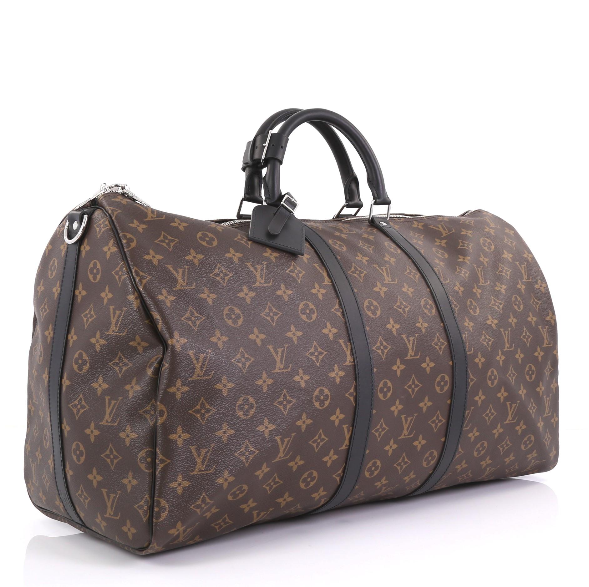This Louis Vuitton Keepall Bandouliere Bag Macassar Monogram Canvas 55, crafted in brown macassar monogram coated canvas, features dual rolled leather handles, black leather trim, and silver-tone hardware. Its two-way zip closure opens to a burgundy