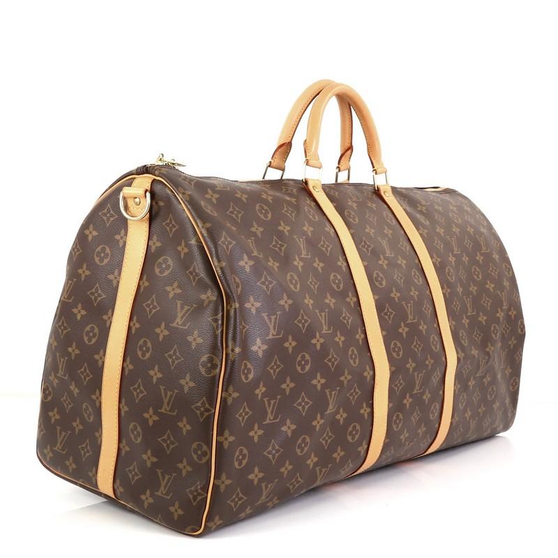 This Louis Vuitton Keepall Bandouliere Bag Monogram Canvas 60, crafted from brown monogram coated canvas, features dual rolled handles, cowhide leather trim, and gold-tone hardware. Its zip closure opens to a brown fabric interior. Authenticity code