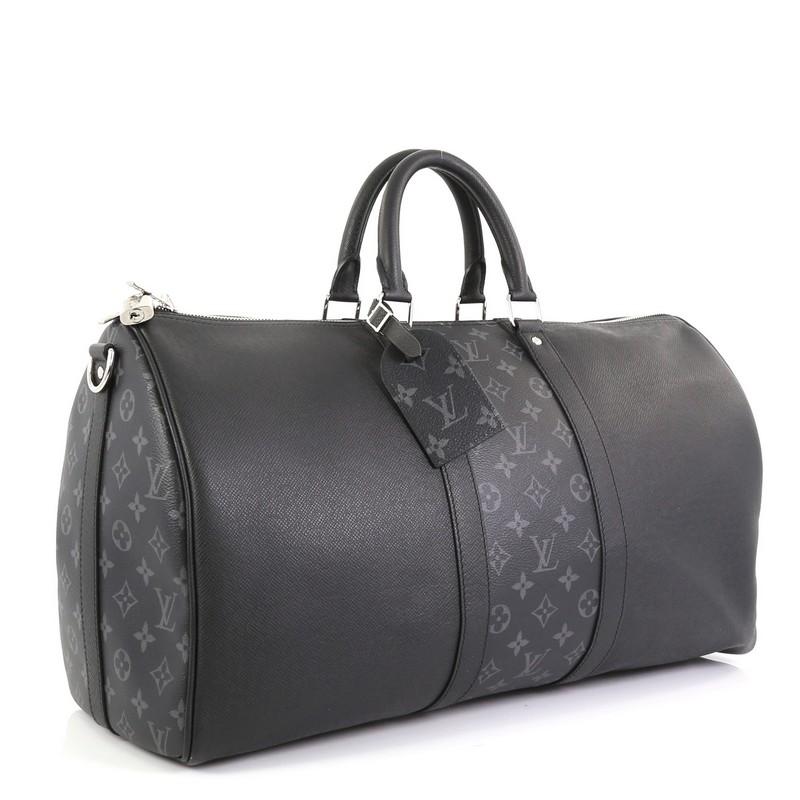 This Louis Vuitton Keepall Bandouliere Bag Taiga Leather and Monogram Eclipse Canvas 50, crafted in black taiga leather with black monogram coated canvas, features dual-rolled leather handles, and silver-tone hardware. Its zip closure opens to a