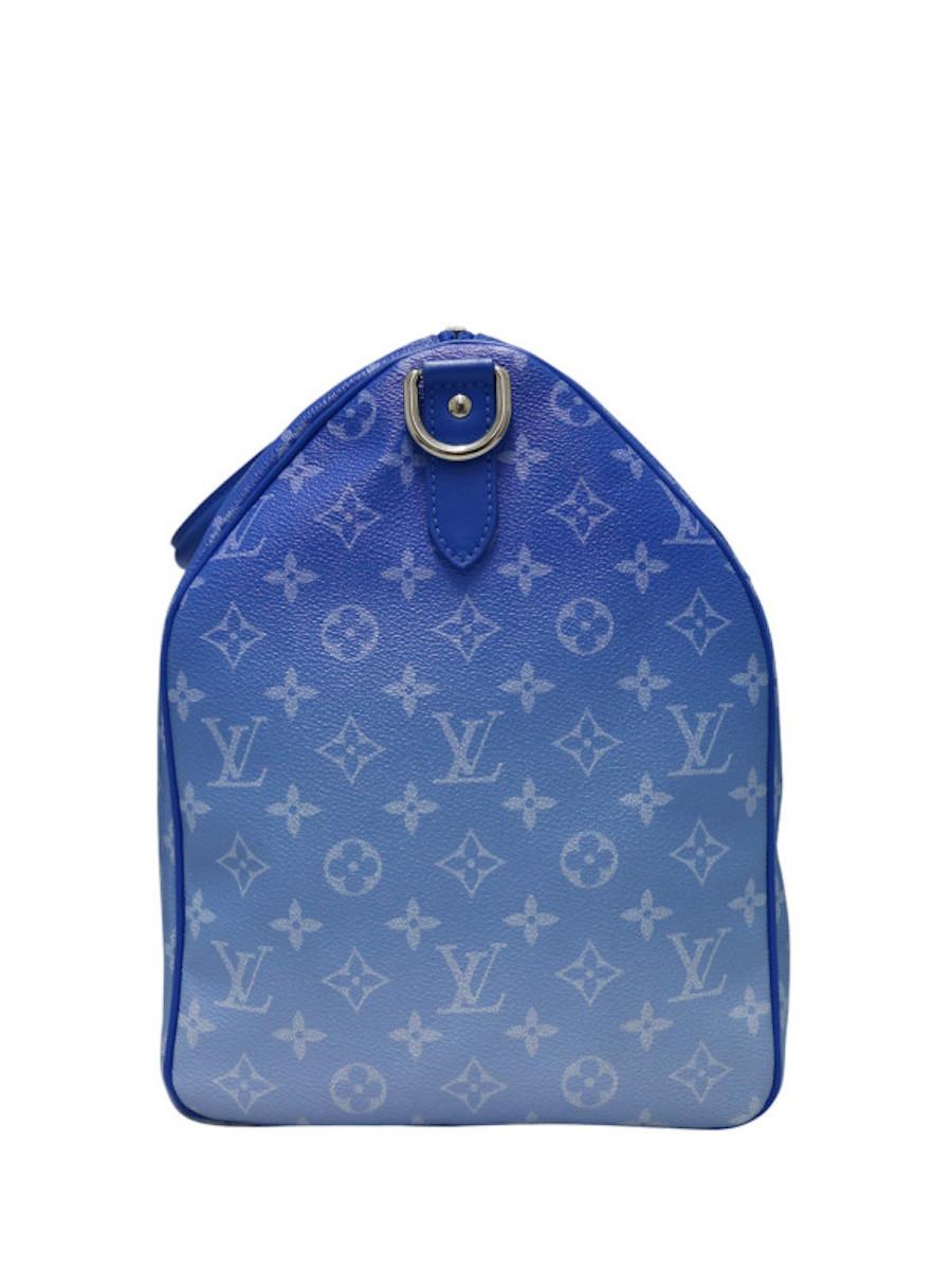 Sac de voyage en édition limitée conçu par Virgil Abloh. Livré avec un porte-adresse, une poche zippée à l'intérieur du sac, le logo LV en forme de nuages blancs, le dégradé de bleu représente le ciel. Livré dans son sac à poussière d'origine Louis