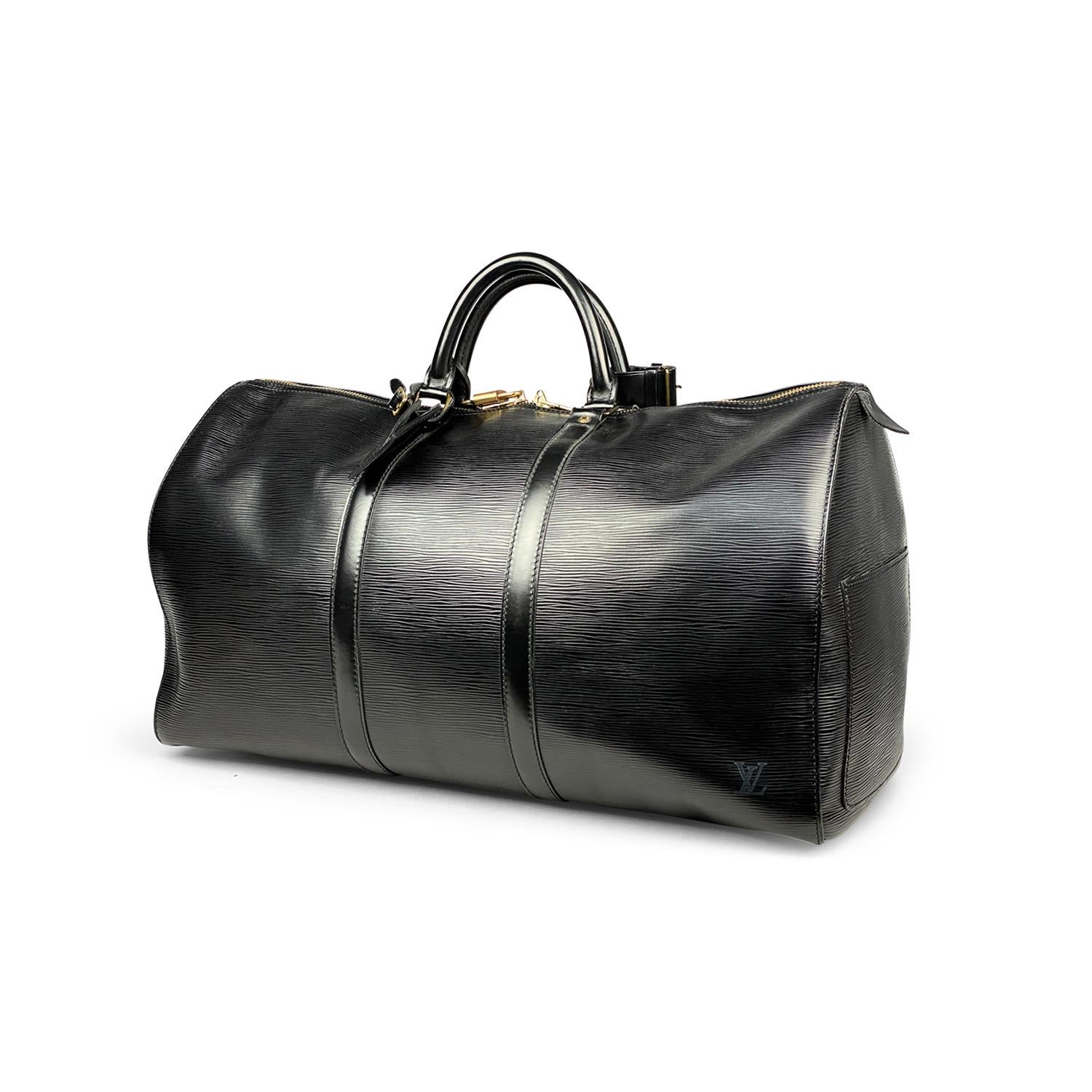 Keepall 50 de Louis Vuitton en piel de epi negra con

- Herrajes de latón
- Doble asa superior enrollada
- Logotipo en relieve en la esquina delantera
- Un bolsillo exterior
- Forro de piel tonal y cierre con cremallera bidireccional en la parte