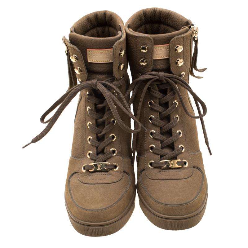 Crafted exquisitely from khaki green suede, these Louis Vuitton ankle boots were built to lift your outfits and your spirits. Lace-ups are perfectly placed on the vamps while sturdy wedges and gold-tone zippers complete the pair.

Includes: Original