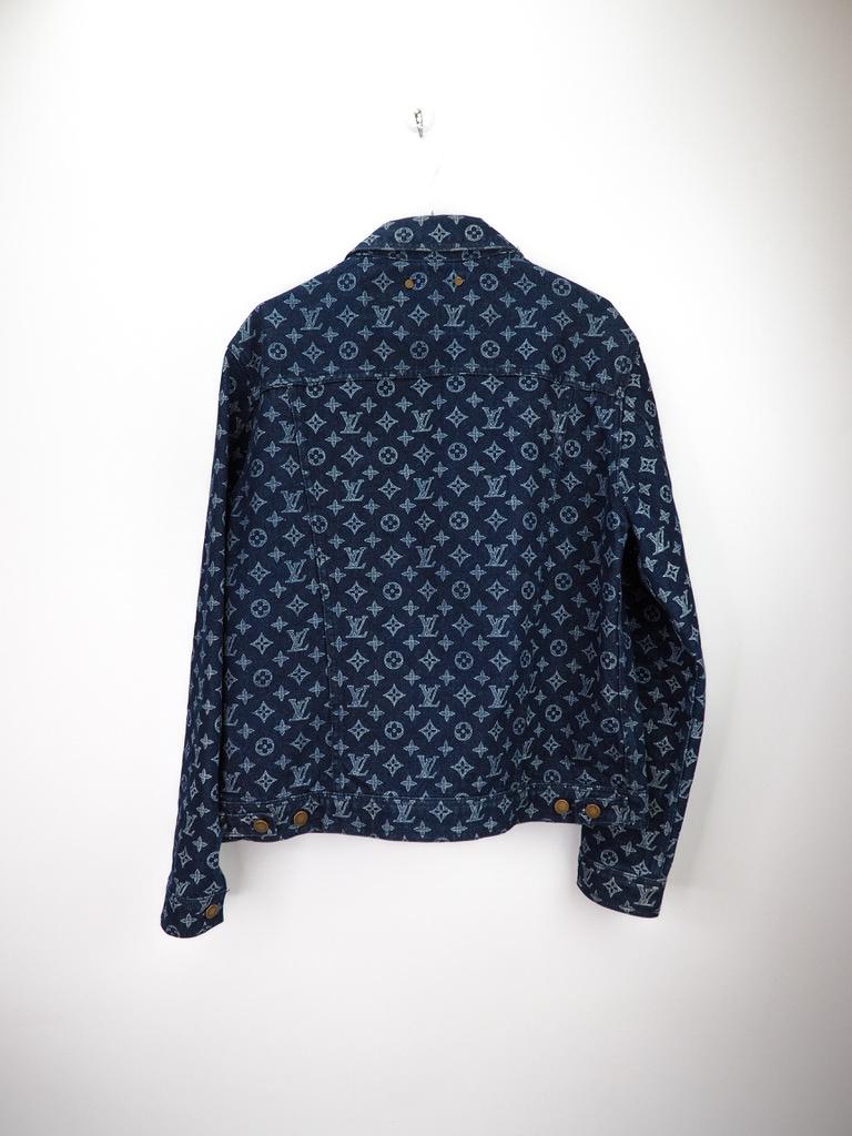This Louis Vuitton jacket is made from denim (100% cotton) and features a navy blue color, the brand's signature monogram print throughout, a simple collar, button front closure, four external pockets, gold-tone hardware and long sleeves with button
