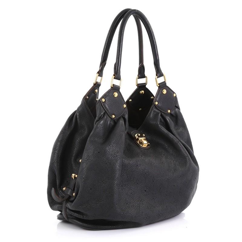 This Louis Vuitton L Hobo Mahina Leather, crafted from black monogram perforated mahina leather, features dual rolled handles, buckle and stud details, side belt straps, protective base studs, and gold-tone hardware. Its engraved top flap push-lock